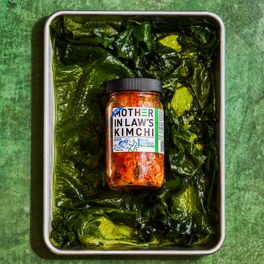 Mother-in-Law’s Seaweed Kimchi jar resting on a tray of fresh seaweed